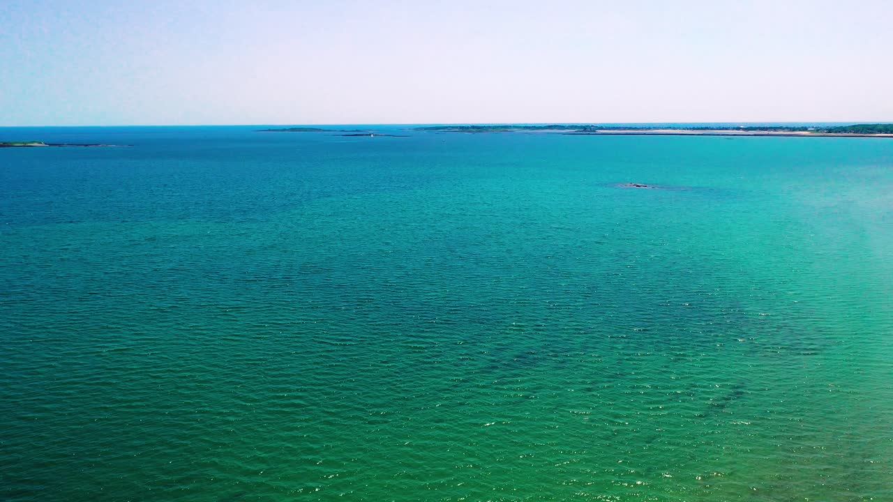 Aerial drone flying high above empty beaches in Saco, Maine during the off-season. No people on the sand, waves crash along the Atlantic shore near vacation homes on the East Coast.