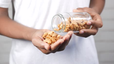 Young men pouring peanuts from a jar ,