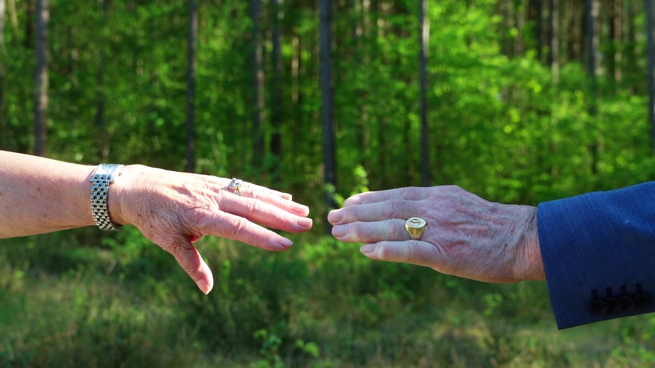 Coppia anziana che si tiene per mano mostrando la loro cura e il loro amore, vista ravvicinata.