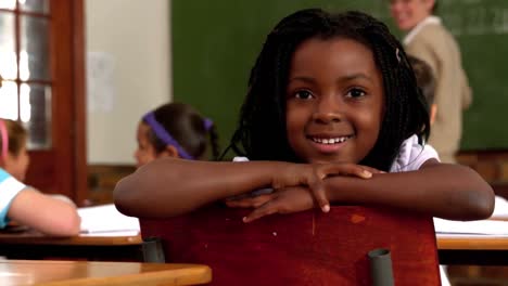 Cute-little-girl-smiling-at-camera-during-class