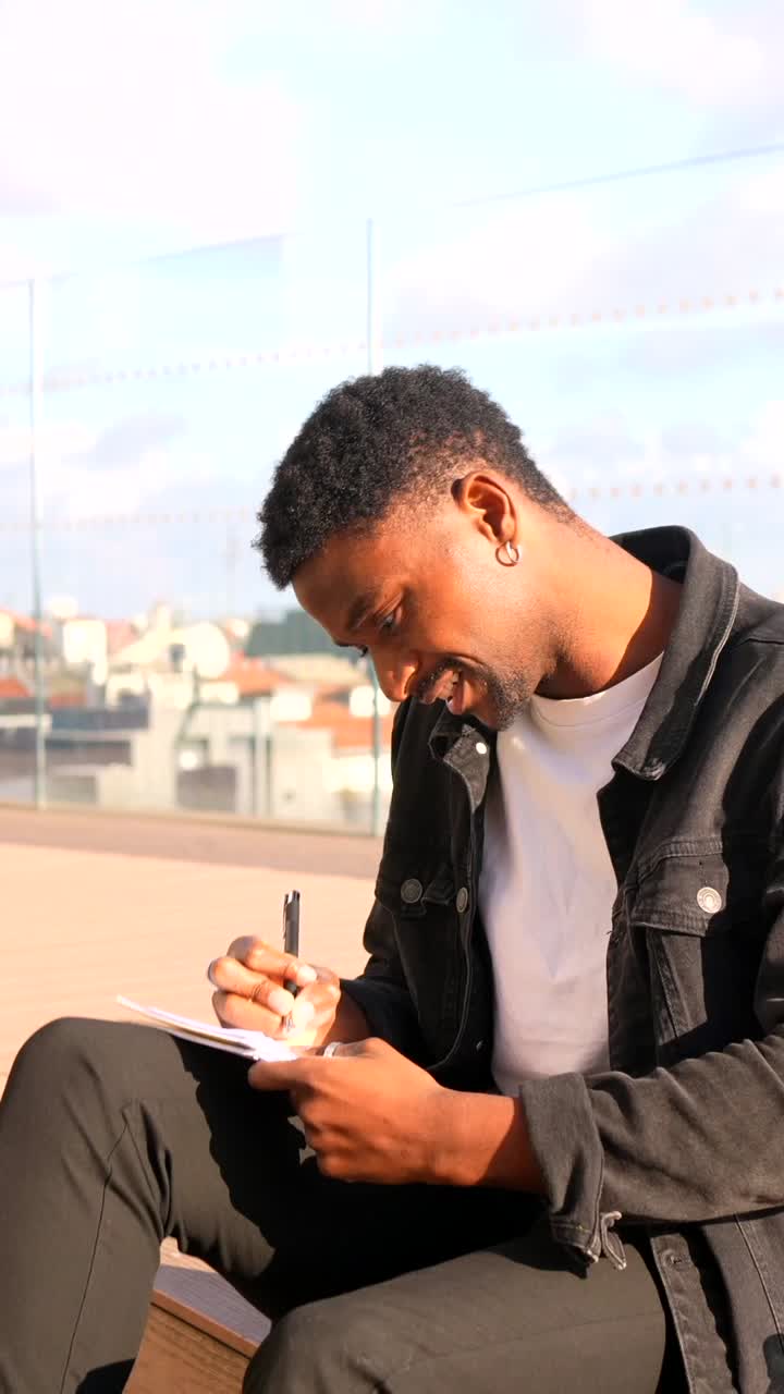 Man writing in notebook in urban setting