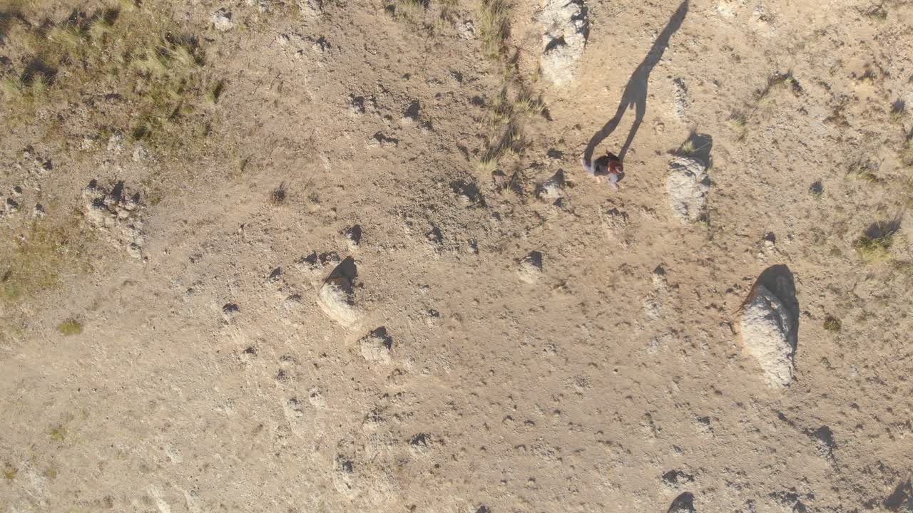 Ragazza che cammina da sola su una strada di pietra verso la cima della montagna grigia a Huaraz, Perù.