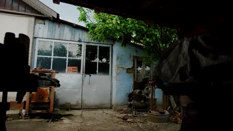 entrance to old home workshop with rusted machinery in the front