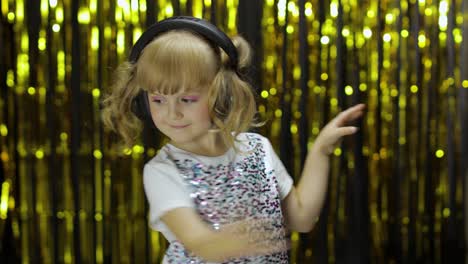 child dances, sings, listens music on headphones. little kid girl having hun, relaxing and enjoying