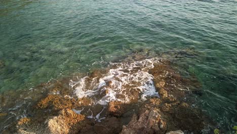 Gentle-waves-hitting-a-rocky-outcropping-on-the-shore-of-Komiza-on-the-island-of-Vis-in-Croatia