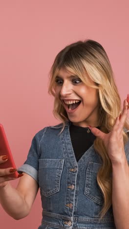 excited transgender woman using smartphone and screaming while celebrating good news