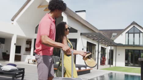 vídeo de um casal feliz e diversificado chegando a um resort de férias ensolarado e tirando uma selfie