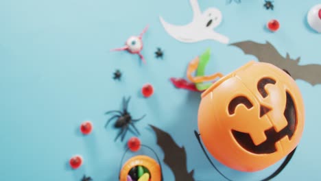 Close-up-view-of-multiple-halloween-toys-and-candies-against-blue-background