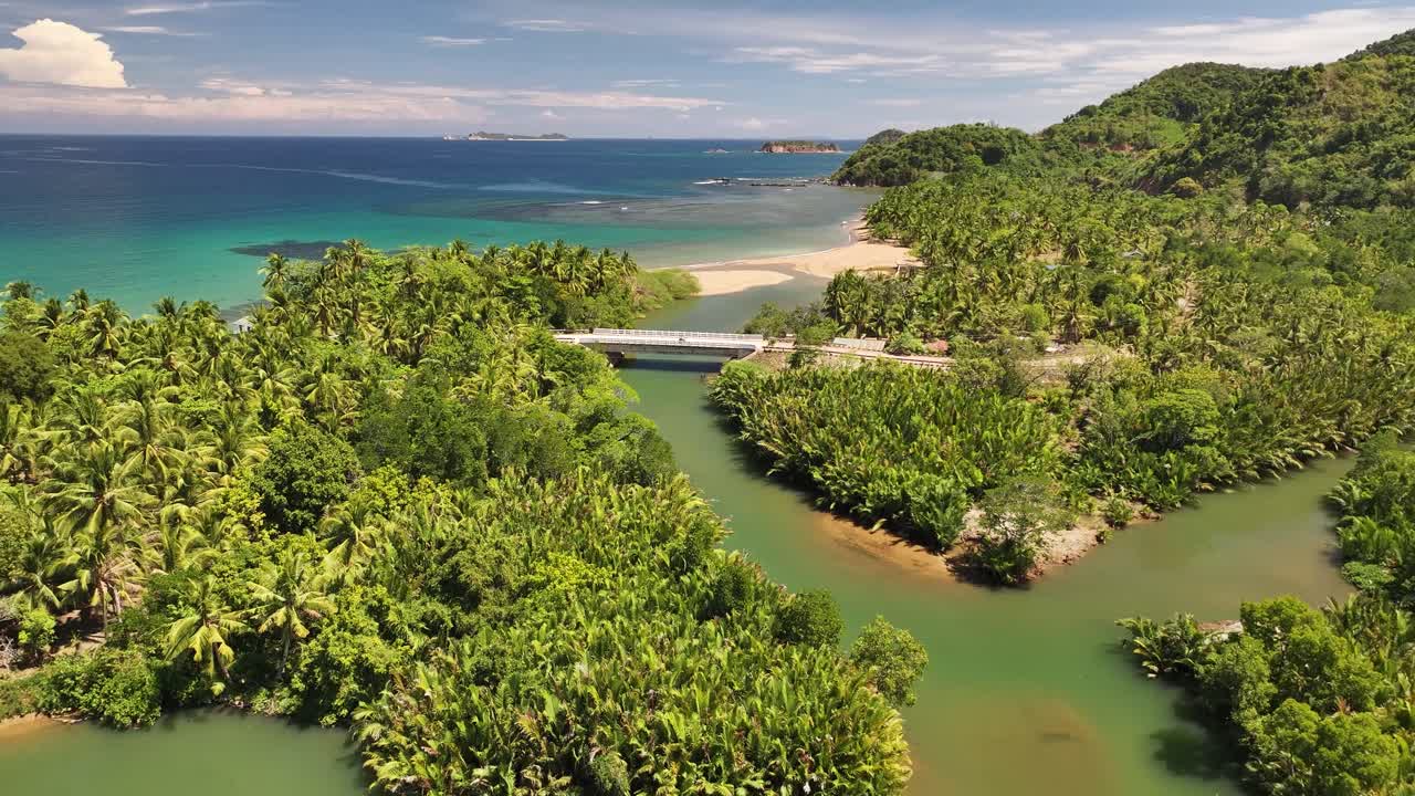 Remote village on Busuanga Island with lush greenery and a bridge crossing a river