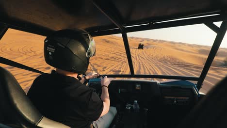 man driving a buggy in the desert sand, off road on dunes, dubai