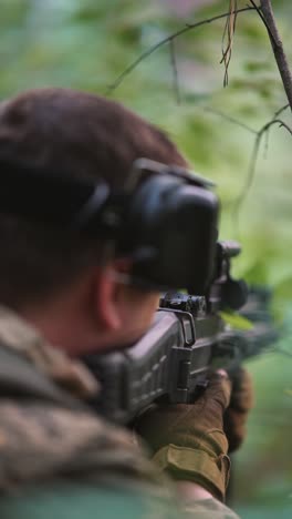 military person with rifle in forest