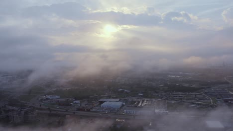 Dröhnen-Durch-Den-Nebel,-Um-Den-Sonnenuntergang-Hinter-Der-Stadt-Zu-Offenbaren