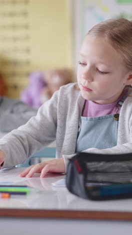 una niña estudiando en un salón de clases