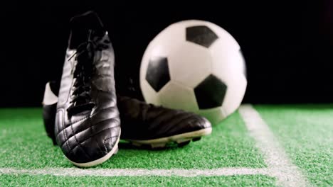 Close-up-of-football-and-cleats-on-artificial-grass-4k