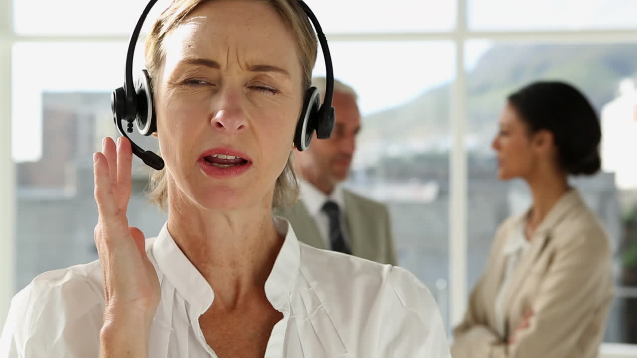 mujer de negocios hablando con auriculares.