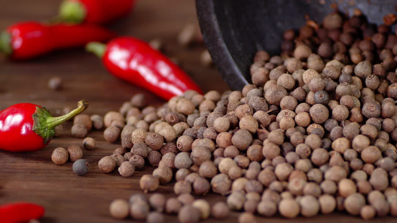 los guisantes de pimienta negra caen sobre la mesa.