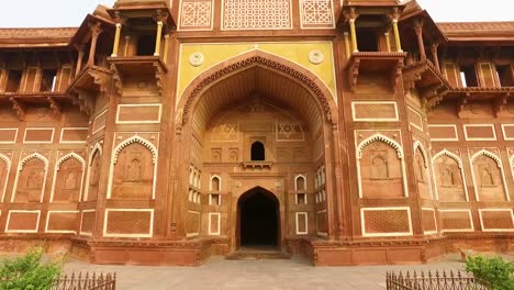 la antigua entrada del palacio jahangir en agra, india con dolly caminando hacia el edificio.