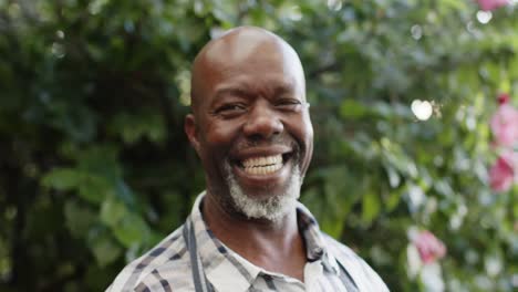 portrait of happy senior african american male shopkeeper in nature, slow motion