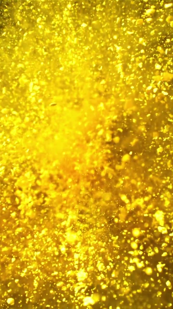 Primer plano de partículas de purpurina dorada remolineando en movimiento abstracto