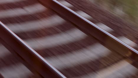 fast passing railway tracks, filmed in the back of a train, looking down