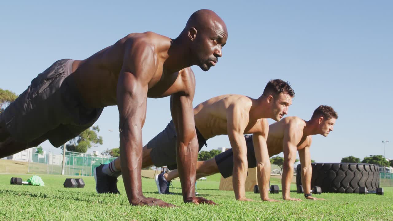 grupo diverso de tres hombres en forma haciendo ejercicio al aire libre, haciendo flexiones