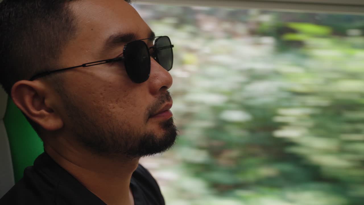Man in Sunglasses Looking Out Train Window During Travel