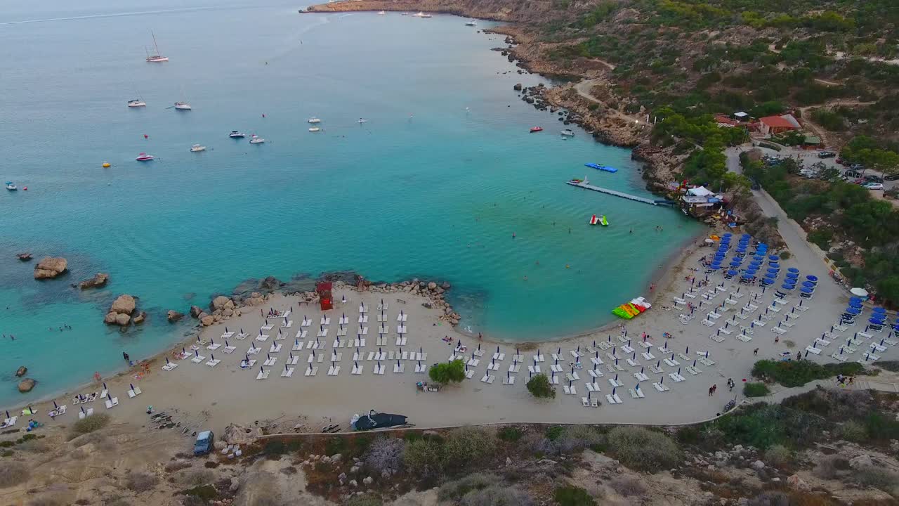 Drone views of world famous Konnos Beach in Mediterranean island of Cyprus late afternoon after sunset with clear turquoise sea water