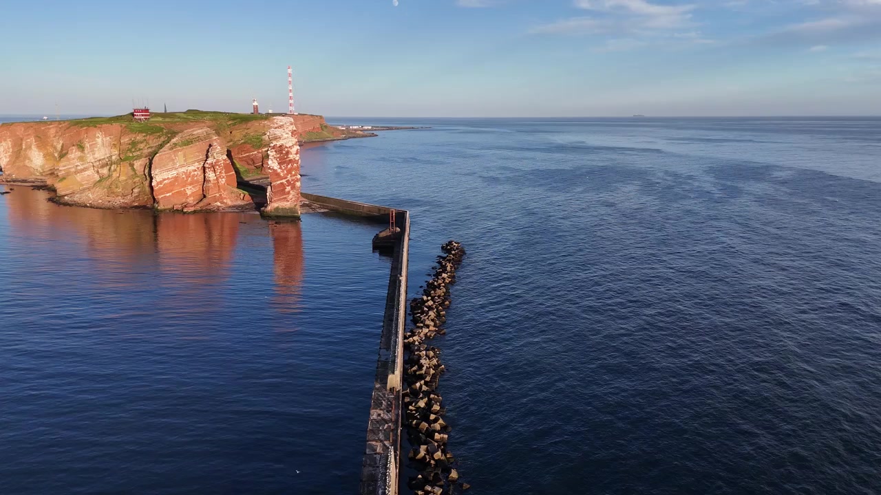 Droneoptagelse ovenfra over en havnemur, der vipper op mod Lange Anna og Helgolands klipper.