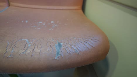 close up of a worn leather chair seat