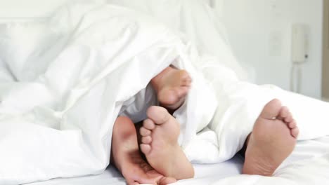 Young-couple-under-duvet-in-their-bed