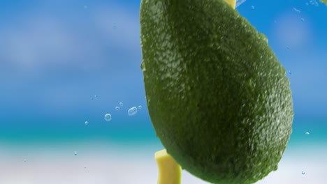 aguacate con rebanadas y salpicaduras cayendo sobre el fondo del cielo