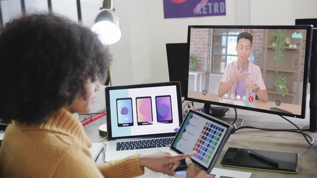 mujer de negocios afroamericana en videollamada con un colega caucásico en la pantalla