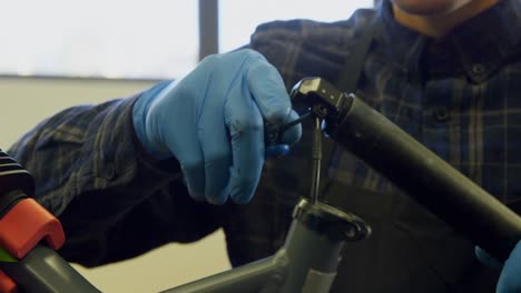 Man-repairing-bicycle-in-workshop-4k