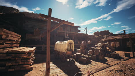 Abandoned western style building with wagon and crates in a desert landscape