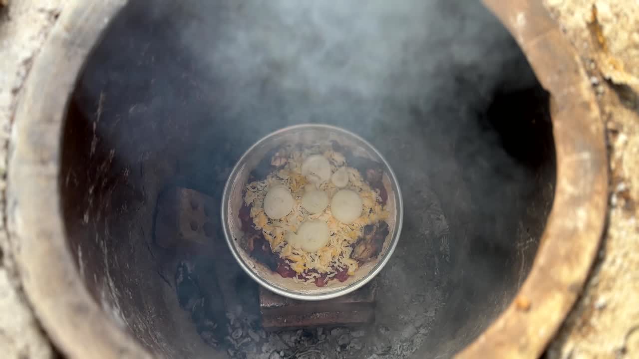 Smoke aroma to chicken onion cheese pizza in a clay mud oven hot fire wood charcoal wood stick cylindrical oven to cook foods and traditional skills of baking bread in local people historical culture