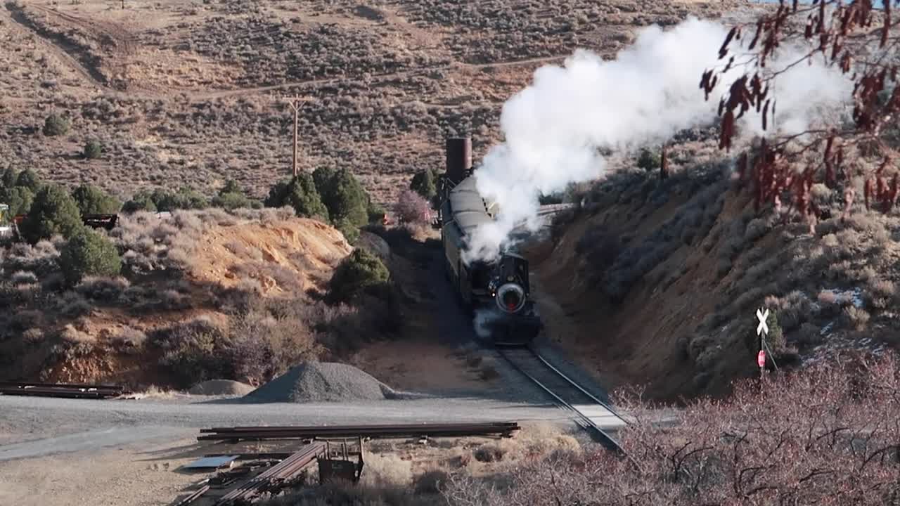 OLD STEAM ENGINE TRAIN MOVING DOWN TRAIN TRACKS