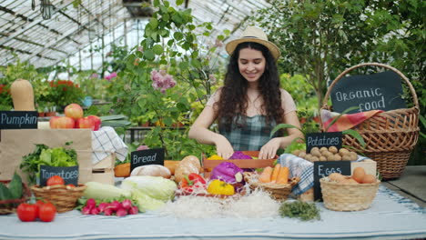 woman selling fresh produce at a greenhouse farm stand