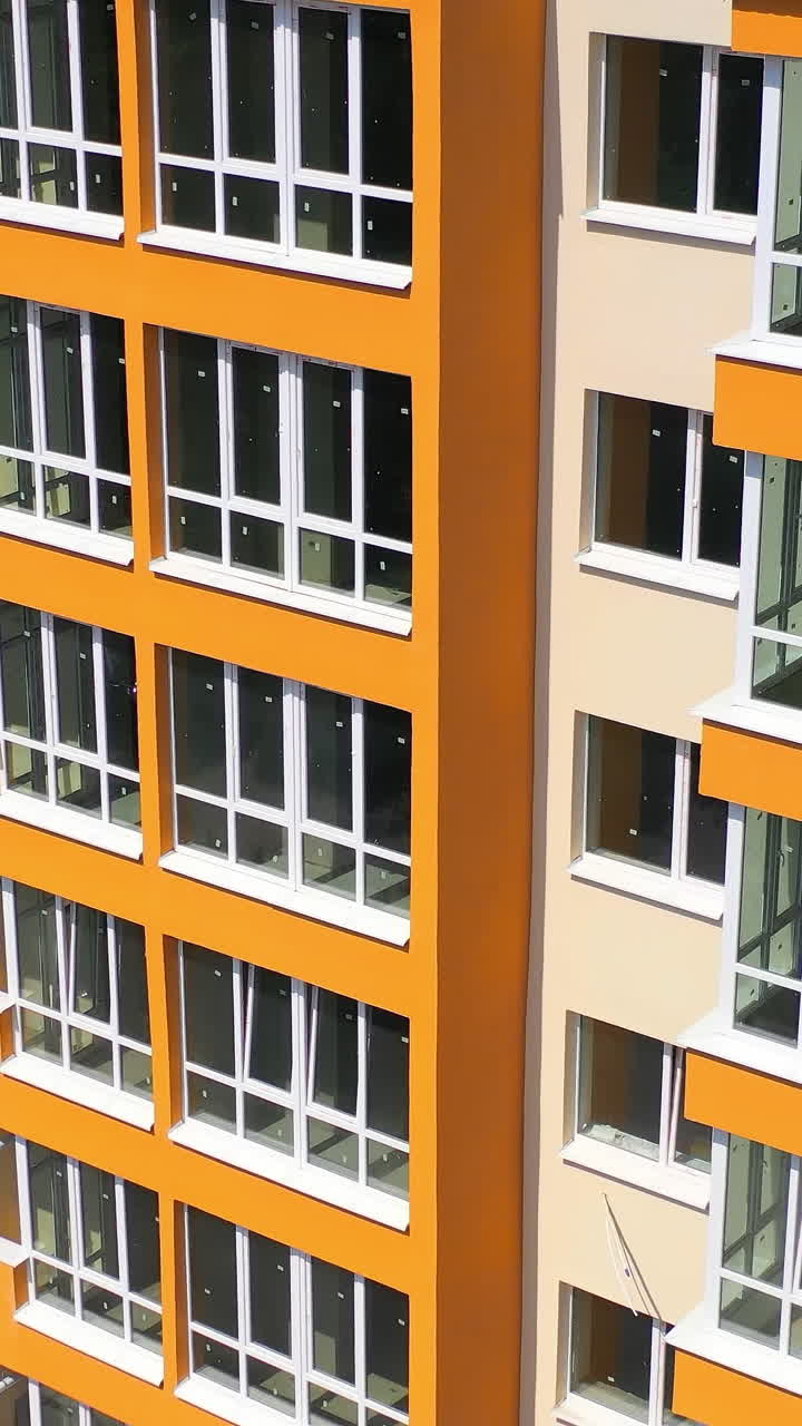 Cropped view of the modern apartment buildings exteriors. Contemporary residential orange and white buildings with outdoor facilities Vertical video