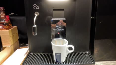 coffee being brewed into a cup from a machine.