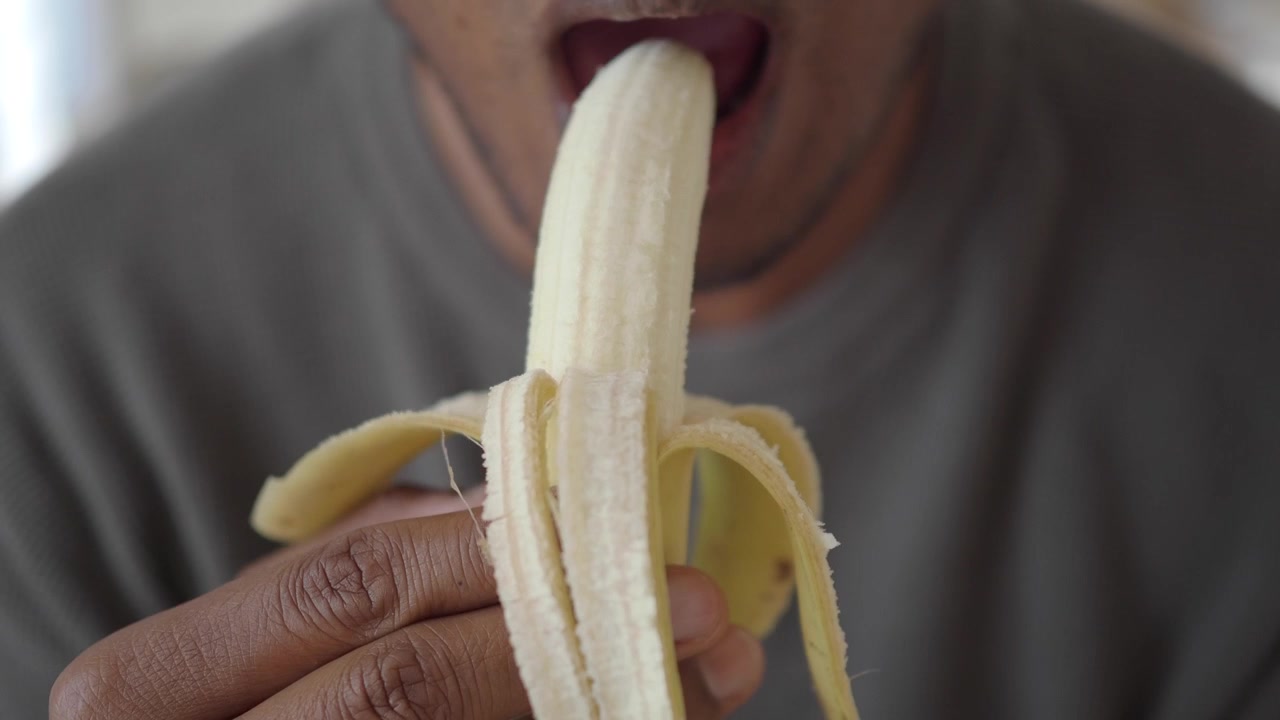 Primo piano di una persona che mangia una banana fresca