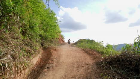 Pareja-Masculina-Y-Femenina-Montando-Ciclomotor-En-Un-Camino-De-Tierra-Hasta-Una-Montaña-En-Un-Hermoso-Día,-Vietnam