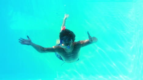 Man-in-snorkel-jumping-in-swimming-pool-waving-at-camera