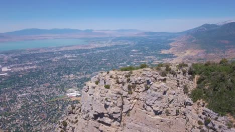 Disparo-De-Dron-De-180-Grados-De-La-Bandera-Estadounidense-Ondeando-En-El-Viento-Con-Vistas-A-Provo,-Utah