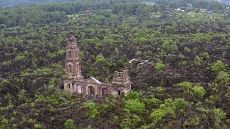 drone: orbit and zoom out of the ruins at san juan parangaricutiro near paricutin volcano