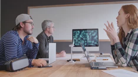 two caucasian men and woman working in a creative office