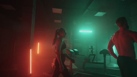 male and female jocks are exercising in gym in night playful pair of sporty people