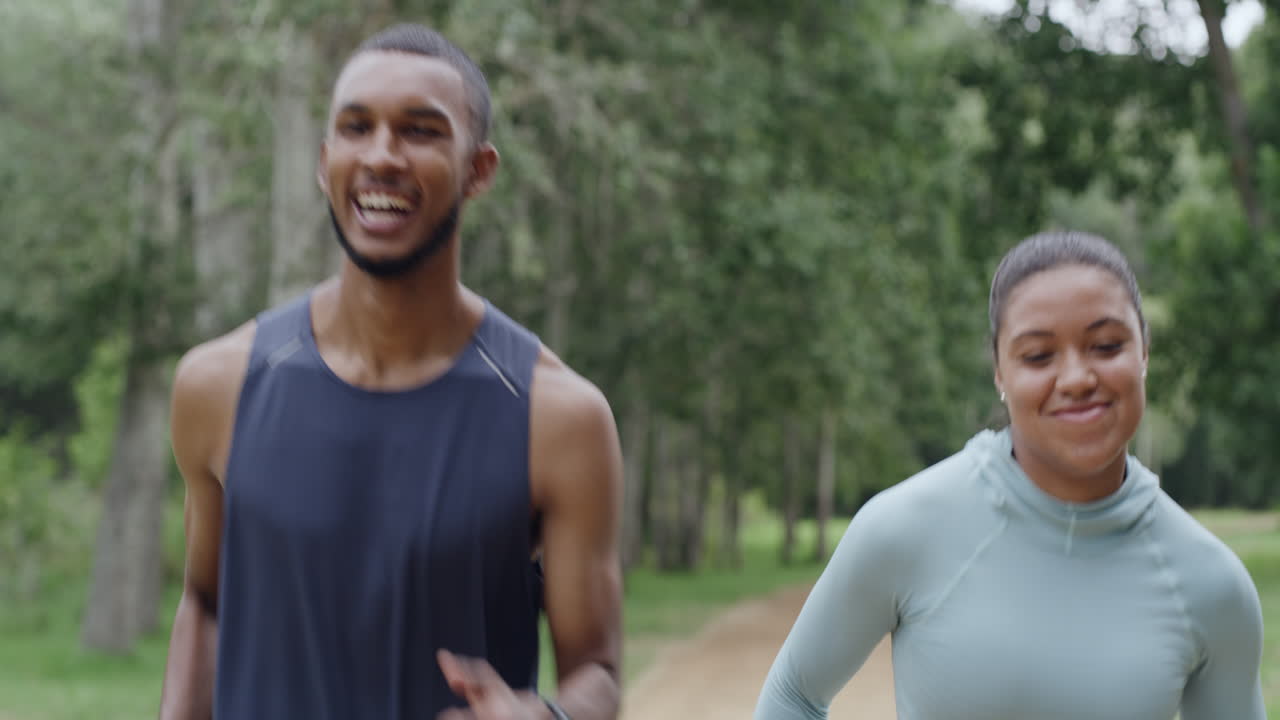 Two fit people running in a park