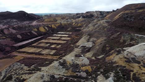 Parys-mountain-abandoned-historic-copper-mine-purple-heather-industry-alien-landscape-aerial-view-forward-right