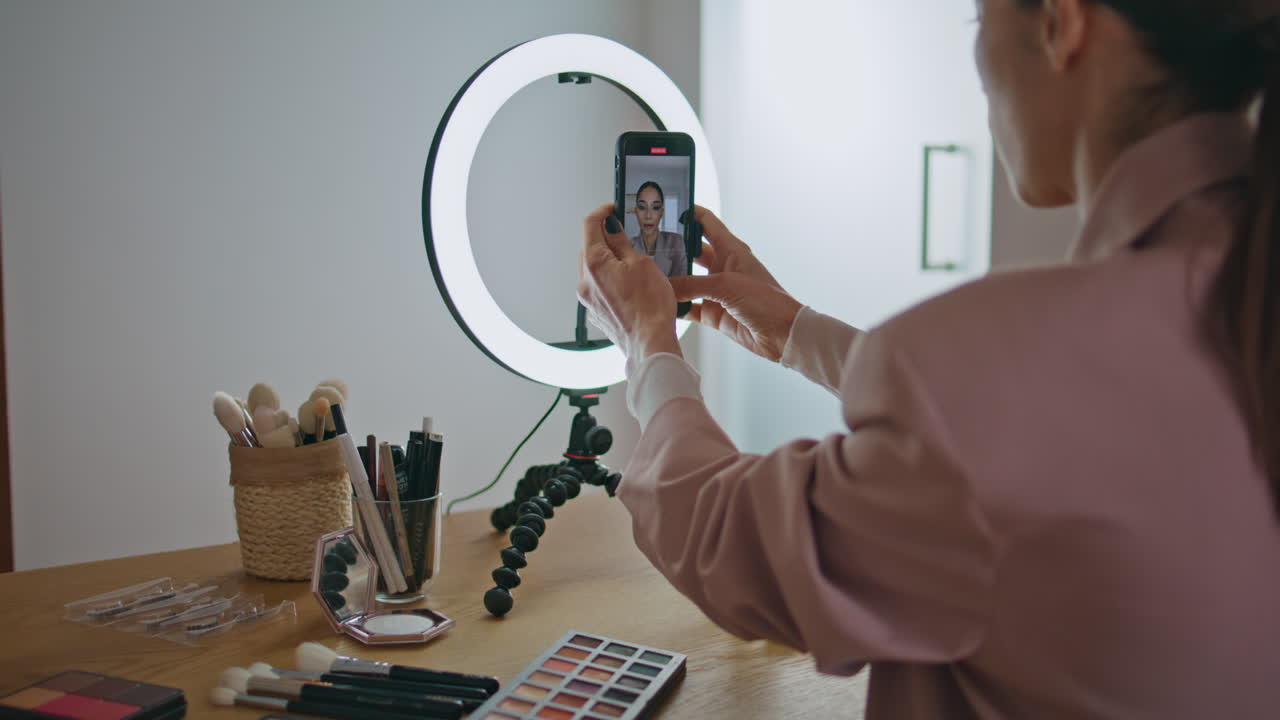 Closeup influencer adjusting smartphone tripod at home. Online learning concept