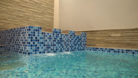 water flowing over jacuzzi into indoor swimming pool